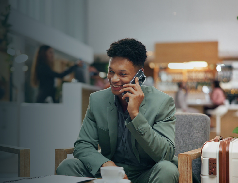 mobile-business-hotel-man-cafe-with-phone-call-coffee-luggage-lobby-trip-communication-travel-booking-happy-businessman-lounge-smartphone-with-hospitality-suitcase-drink